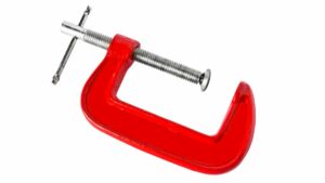 Red screw clamp tool depicted on an angle isolated on white backgroun