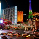 La Franja de Las Vegas de Noche. El Horseshoe y la Torre Eiffel del París Iluminados Entre el Tráfico