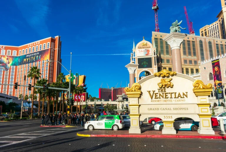 People and cars wait to cross street near The Venitian resort, hotel