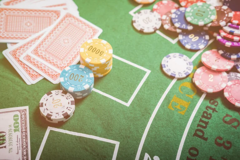 Gambling chips and cards on a green cloth Casino table