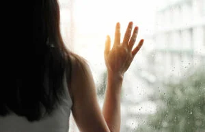 Woman Looking through Glass Raindrops