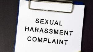 former pointsbet employee caroline weeks files lawsuit over sexual harassment and discrimination. White paper on clipboard reads sexual harassment complaint in black