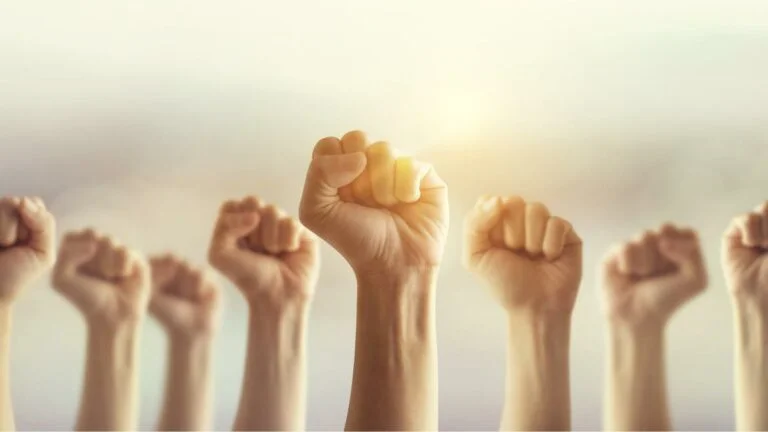 casino workers in vegas and detroit vote to authorize strike. ghands raised in fists punch the air