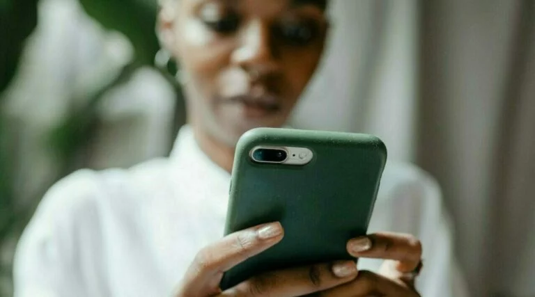 A woman uses a phone like Hard Rock Bet wagerers do in Florida.