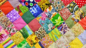 a close up of a brightly colored patchwork quilt lain flat