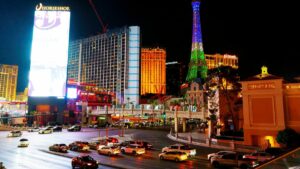 Vegas strip at night. The Horseshoe and Paris' Eiffel Tower illumunated amoong bustling traffic