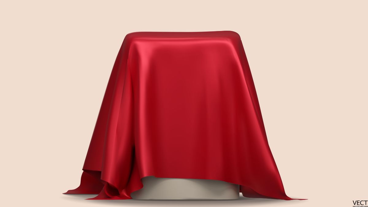 Beige background. A podium is centered in the forefront with a red, silky cloth draped over it, pre-reveal