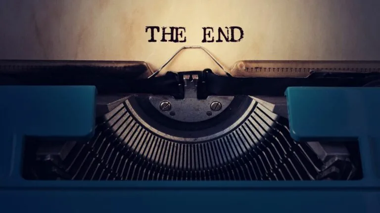 close up of a retro blue typewriter paper inside reads the end