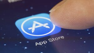 A finger touching the App Store icon on their phone