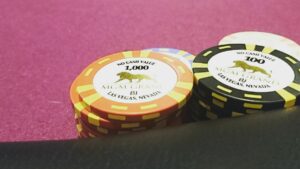 a stack of mgm grand poker chips on a poker felt