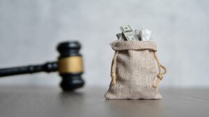 a bag of money next to a gavel