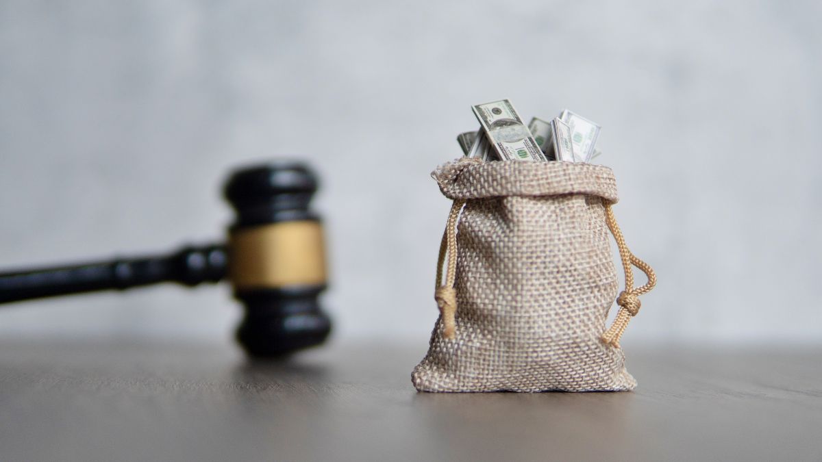 a bag of money next to a gavel