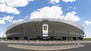 panorama of nassau coliseum against blue sky with fluffy clouds. Horizontal New York Jets and Long Island Nets banner featured front and center