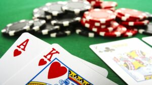 a poker hand being held up on a poker table filled with chips and cards