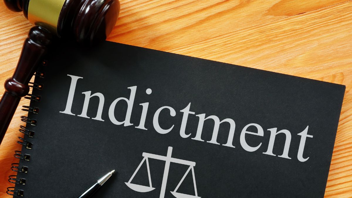 a gavel sitting next to a folder with indictment on it