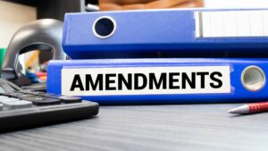 a pair of blue folders on a law desk with the word amendment on one