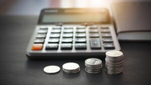 a budget calculator with stacks of coins in front of it