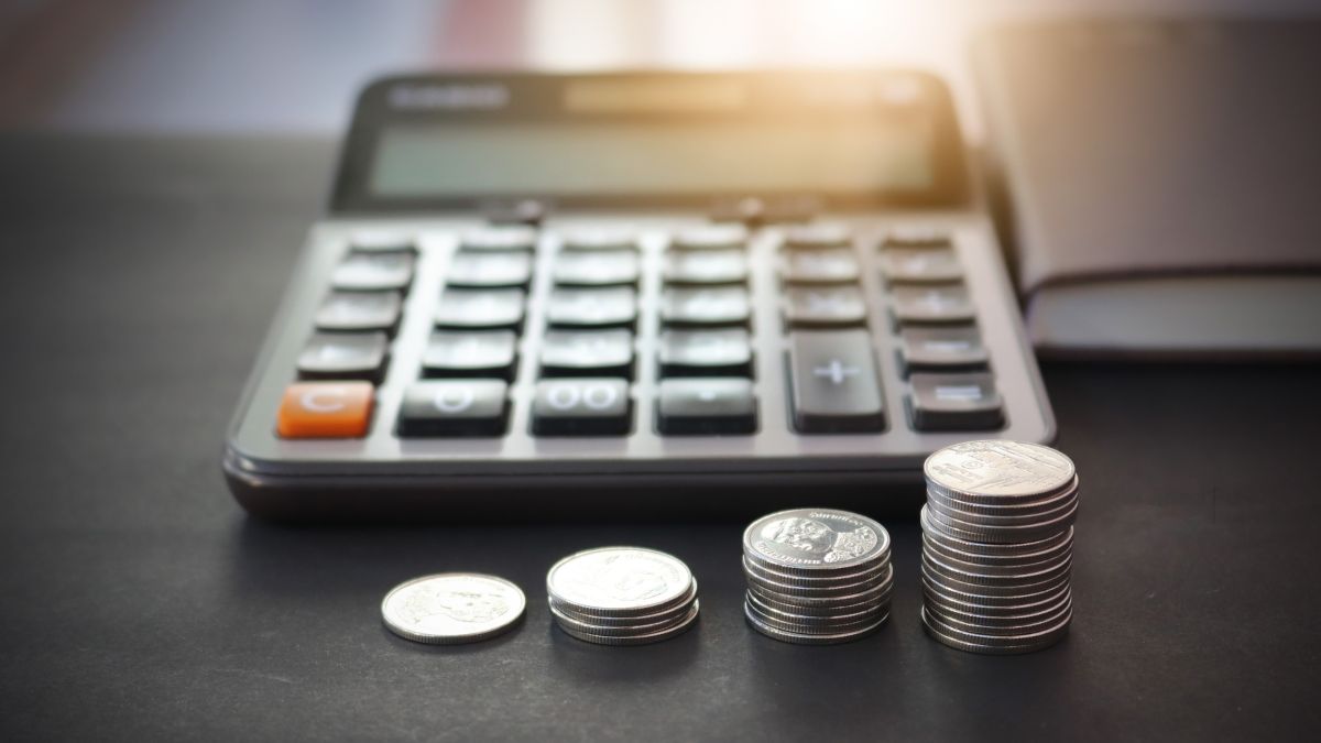 a budget calculator with stacks of coins in front of it
