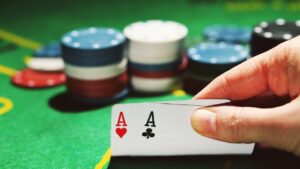 a poker hand of pocket aces in front of a stack of chips