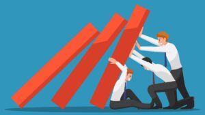an illustration of three workers attempting to stop a set of dominos from tumbling over