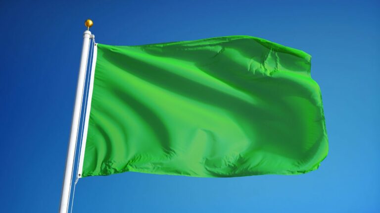 a green flag waving in the sky