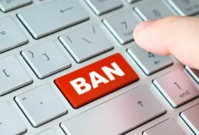 a keyboard with a red ban button about to be pressed