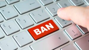a keyboard with a red ban button about to be pressed