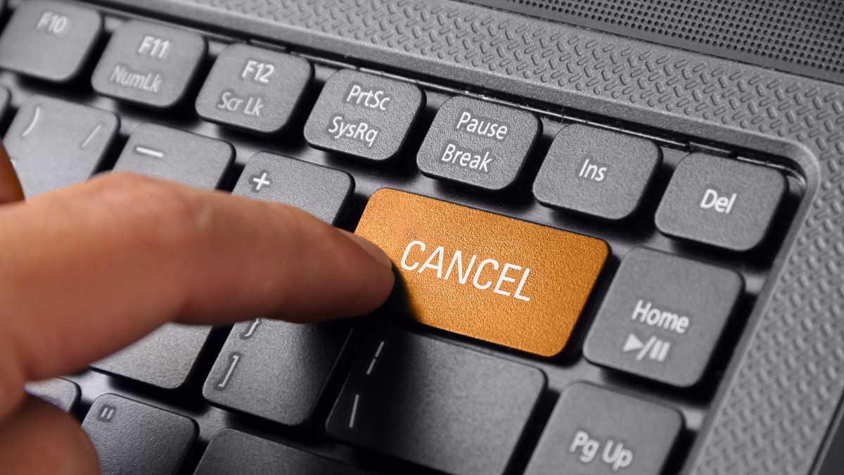 a finger hitting a key on a keyboard that reads cancel
