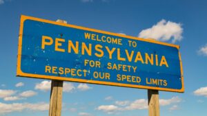 Retro Pennsylvania blue and gold road sign reads welcome to Pennsylvania and asks drivers to respect road rules