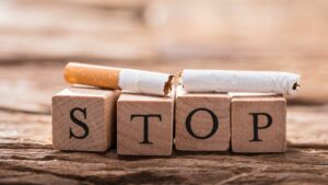 four blocks that spell out stop with a cigarette broken in half on top of them