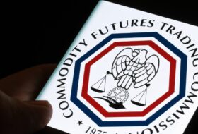 a person holding an image of the cftc logo