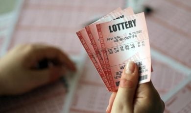 A young woman holds the lottery ticket with complete row of numbers