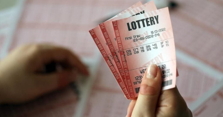 A young woman holds the lottery ticket with complete row of numbers