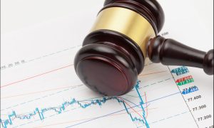 Judge's gavel and calculator over stock market chart