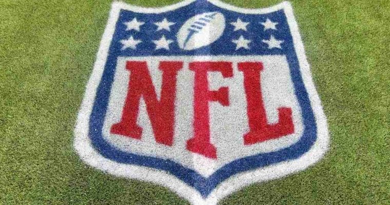 An NFL logo on a green artificial grass football field line