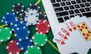 Casino Chips and Playing Cards on Laptop Computer for Virtual Poker Betting and Gambling Strategy