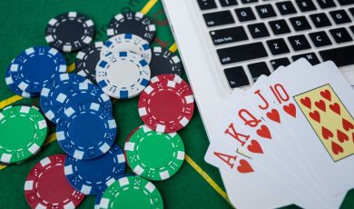 Casino Chips and Playing Cards on Laptop Computer for Virtual Poker Betting and Gambling Strategy