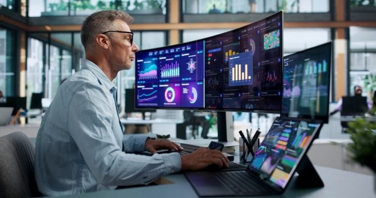 Financial Analyst Pointing At Predictive Dashboard While Monitoring Market Trends Data