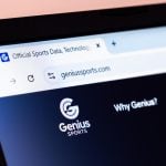 Genius Sports company website homepage displayed with logo on laptop screen