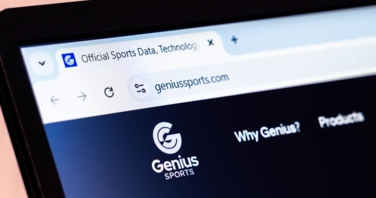 Genius Sports company website homepage displayed with logo on laptop screen