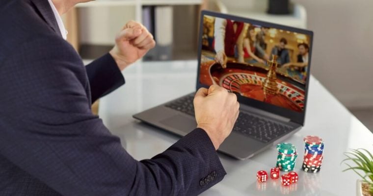 Guy with poker chips on table, playing an online casino game