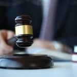 Judge holding hammer in hand lies