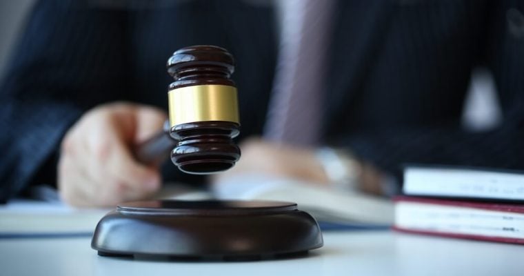 Judge holding hammer in hand lies