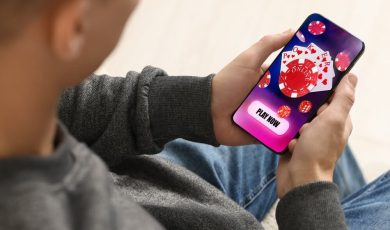 Man playing online poker on mobile phone indoors