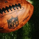 NFL ball placed on green grass in beautiful light