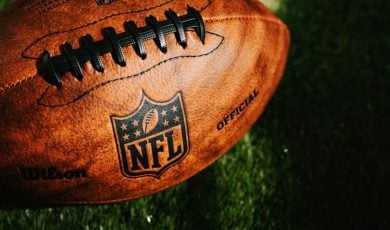 NFL ball placed on green grass in beautiful light