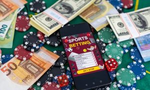 Sports Betting on a smartphone surrounded by poker chips and US dollars