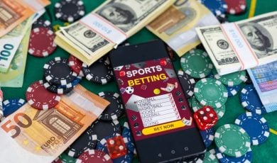 Sports Betting on a smartphone surrounded by poker chips and US dollars