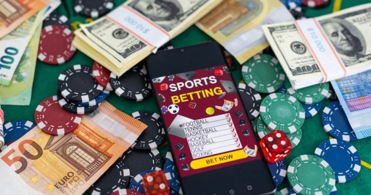 Sports Betting on a smartphone surrounded by poker chips and US dollars