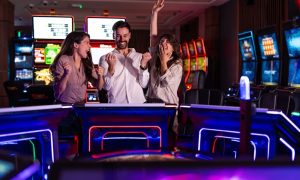 Three cheerful friends enjoy a fun time at a vibrant casino arcade